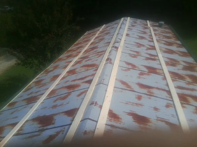 Rusted metal roof panels with new wood purlins before replacement — Storm Damage Roof Repair in Ottine by Roofing Brothers